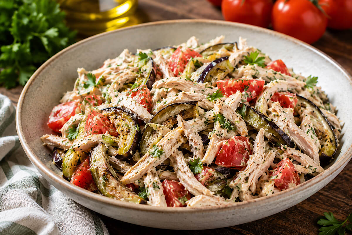 Insalata di pollo sfilacciato con melanzane, pomodori e maionese alle erbe