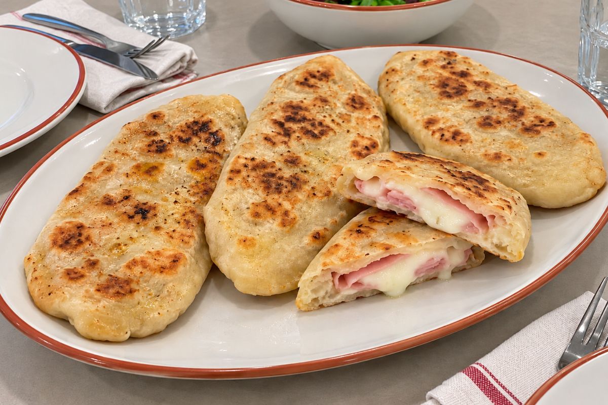 Lingue di focaccia in padella con prosciutto e formaggio